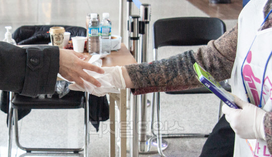 유권자에게 일회용 비닐장갑 나눠주는 모습.